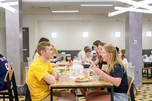 Male and female students eating together. 