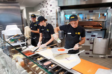 Student employees making pizzas. 