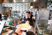 Female student employee serving an omelette. 