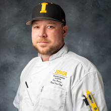 photo of white man in chef's jacket wearing Iowa ball cap