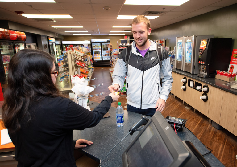 Student checking out with credit card at counter