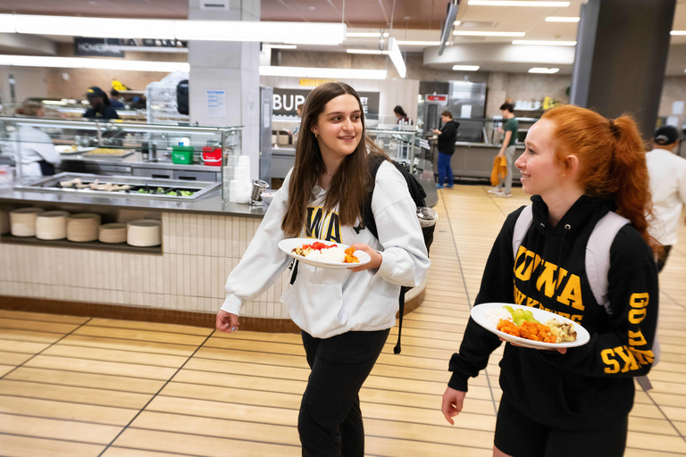 Two students walking and talk with one another