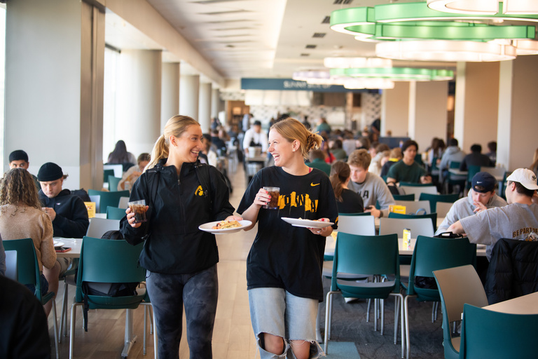 Two girls with food talking with one another