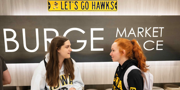 Two female hawkeye students meet at Burge Market Place