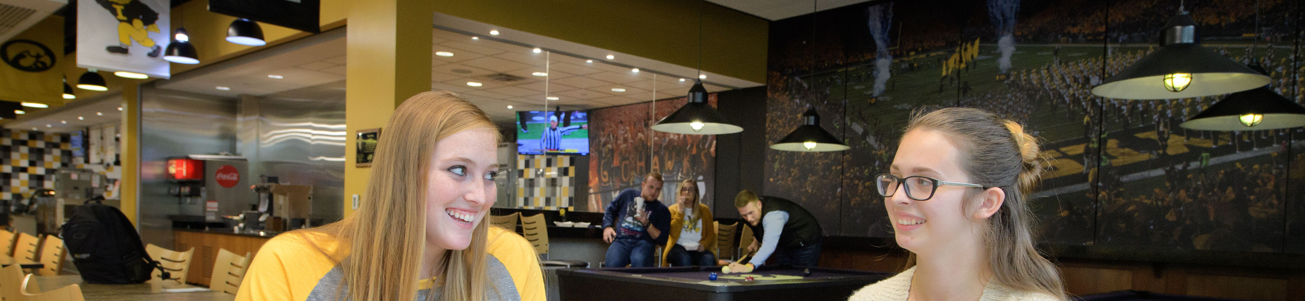 students study and play pool at Black's Gold Grill in Petersen Residence Hall