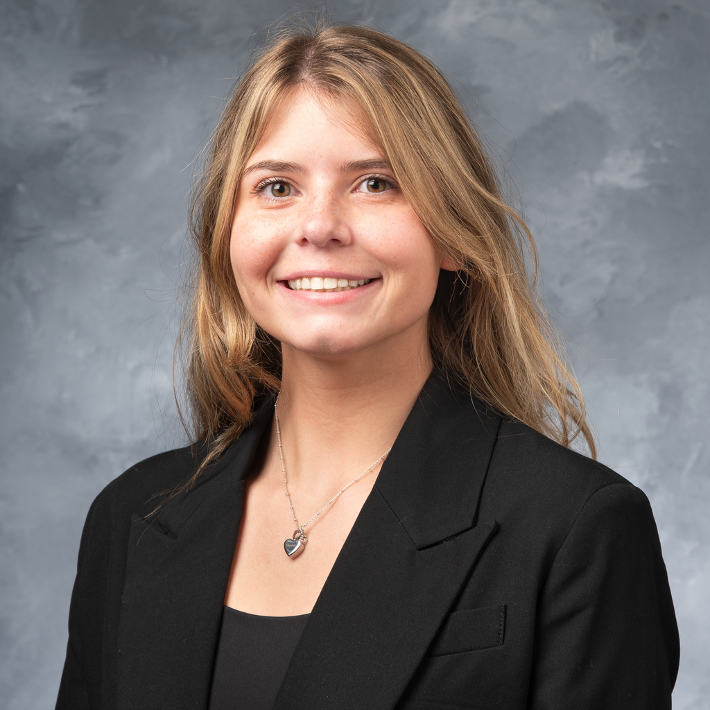 portrait of blond woman with black blazer and heart necklace