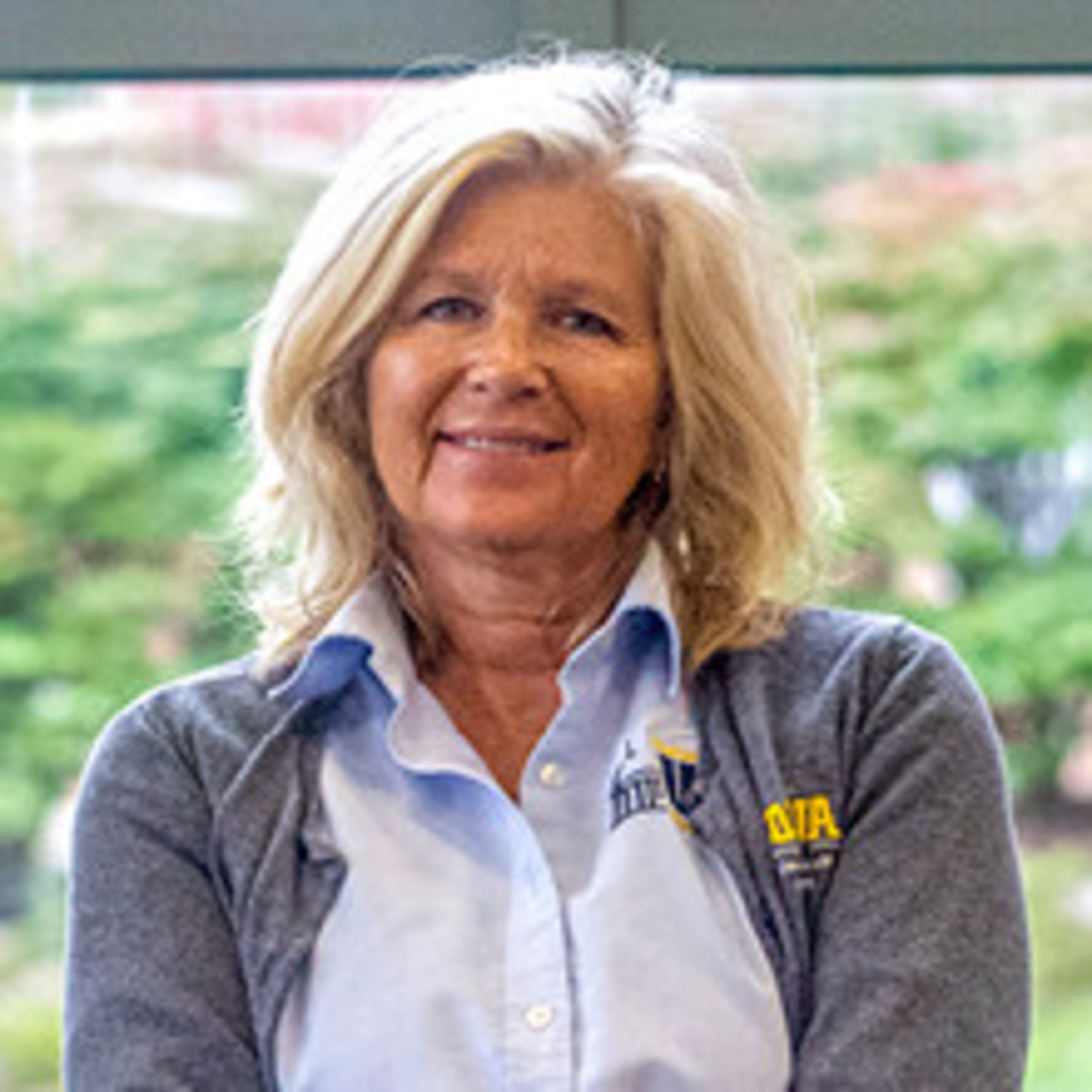 headshot of assistant manager Lisa, a blond woman wearing UHD button-down and sweater