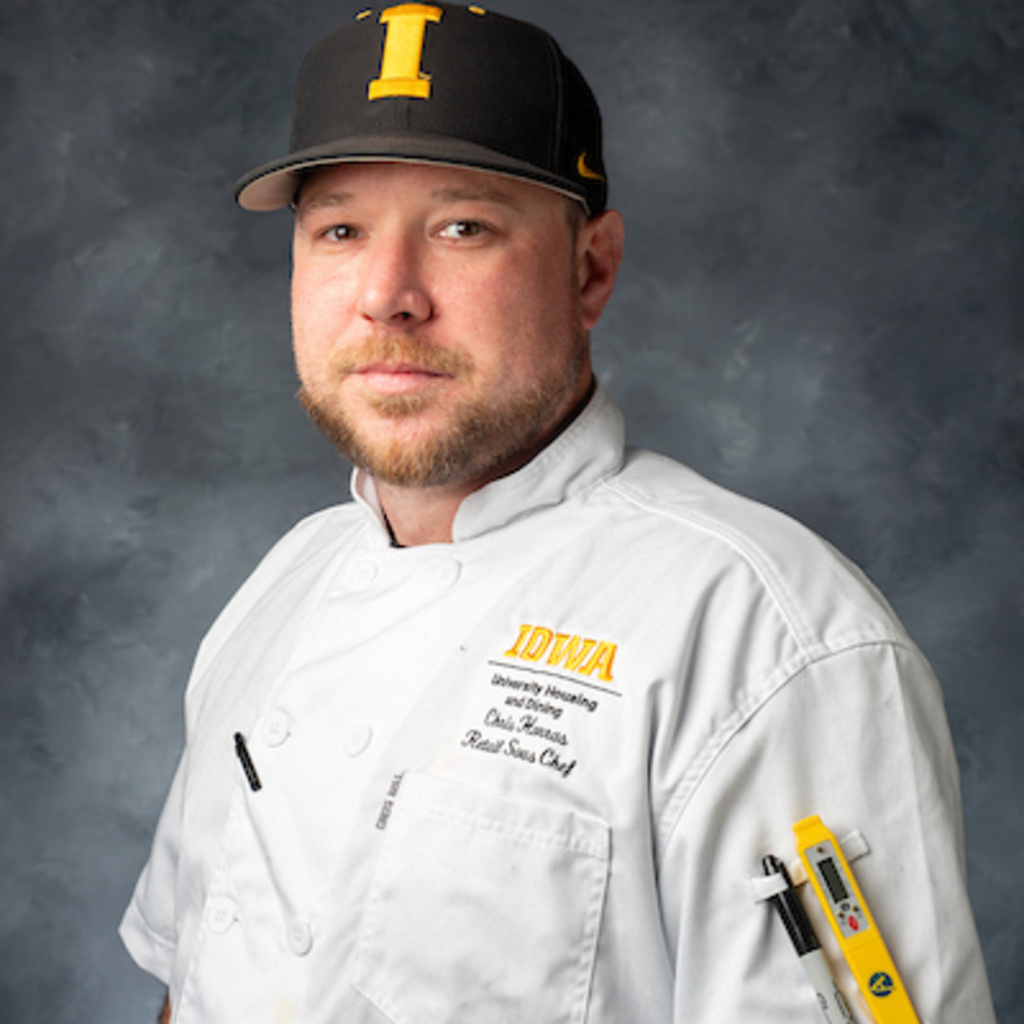 headshot of white man wearing white chef's coat and black ball cap