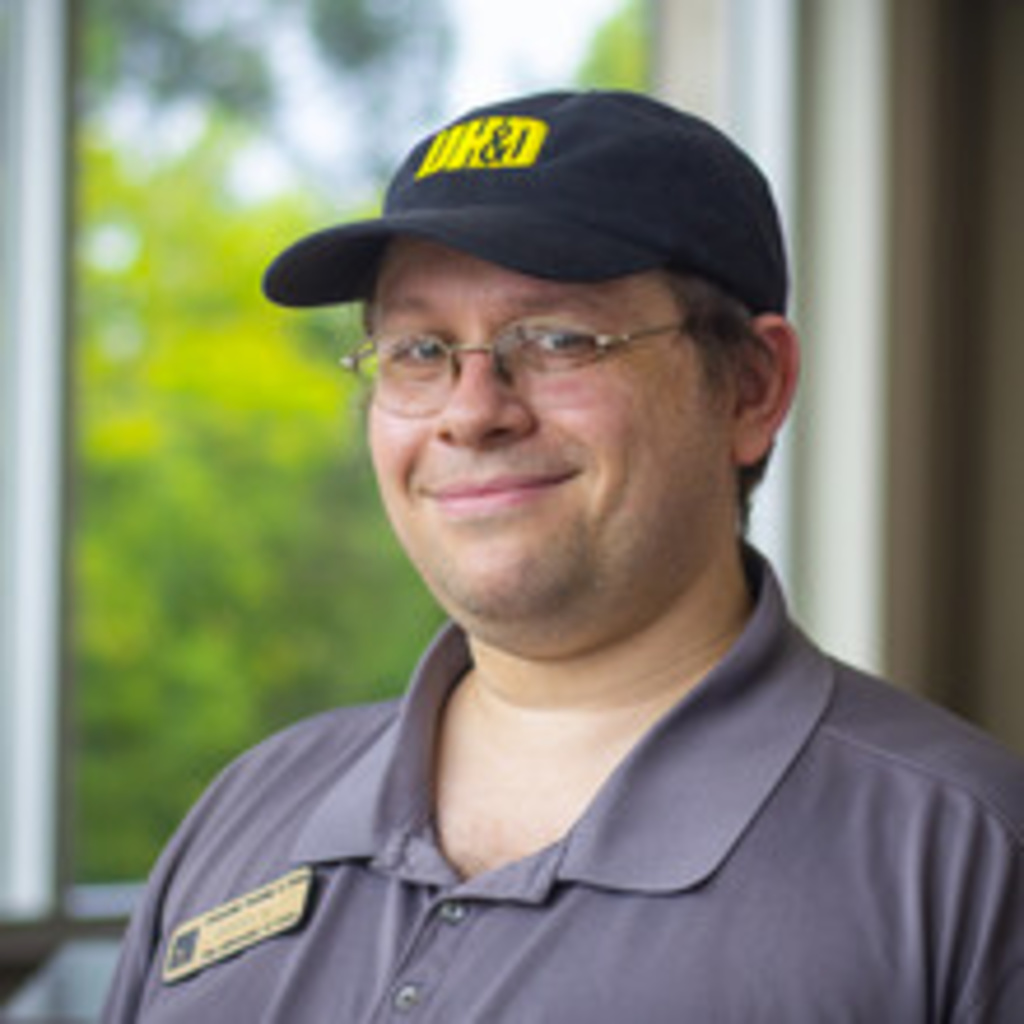 headshot of manager Terry, white man with glasses wearing a black UHD ballcap and gray UHD polo shirt