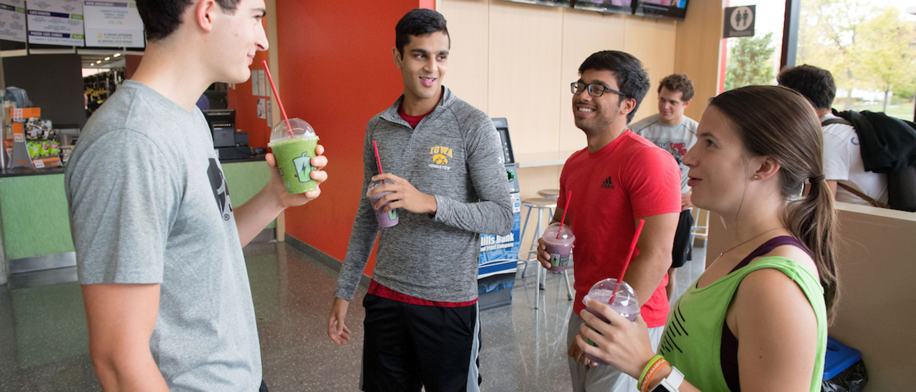 a group of four students drinking smoothies in front of Power Cafe