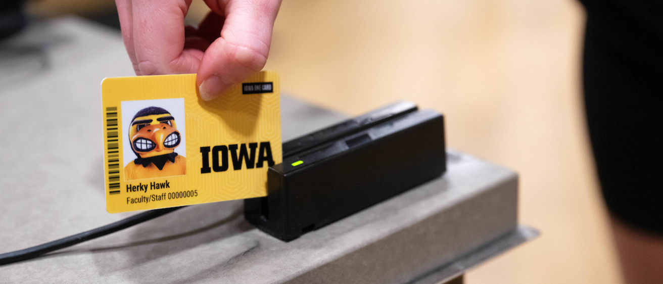 student swiping Iowa One card for a meal in the market place