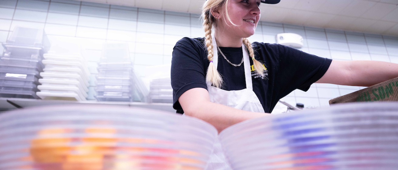 student worker preparing fruit baskets for River Room