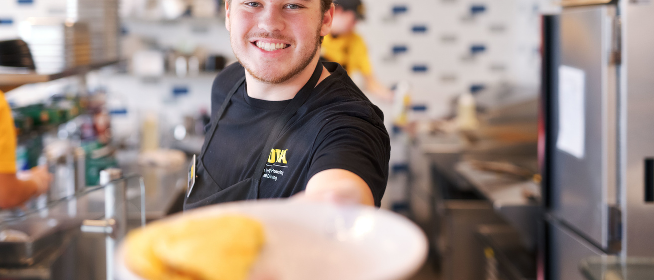 Student handing plate of food