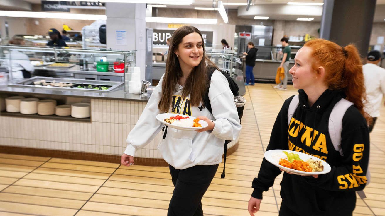 Two students walking and talk with one another